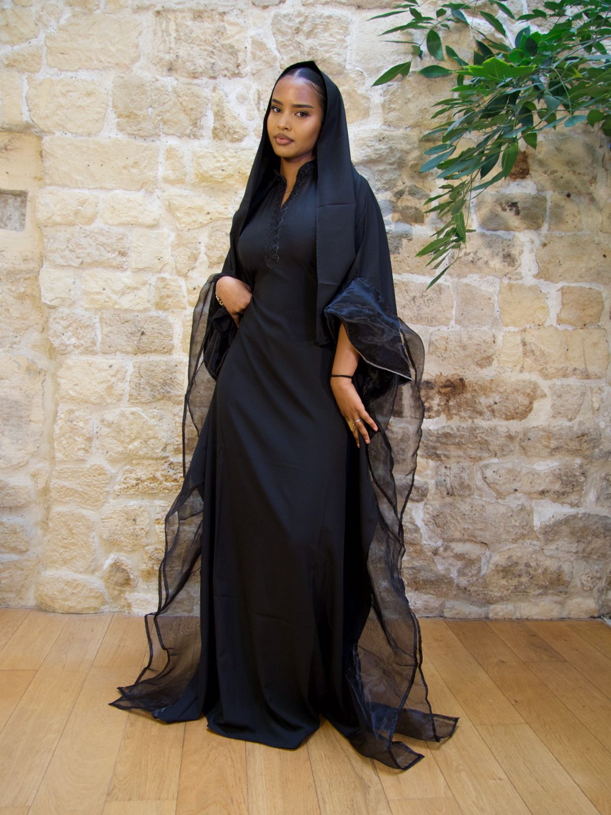 Femme portant la Hasna Dress noir – robe longue noir africaine en organza, élégante avec un foulard