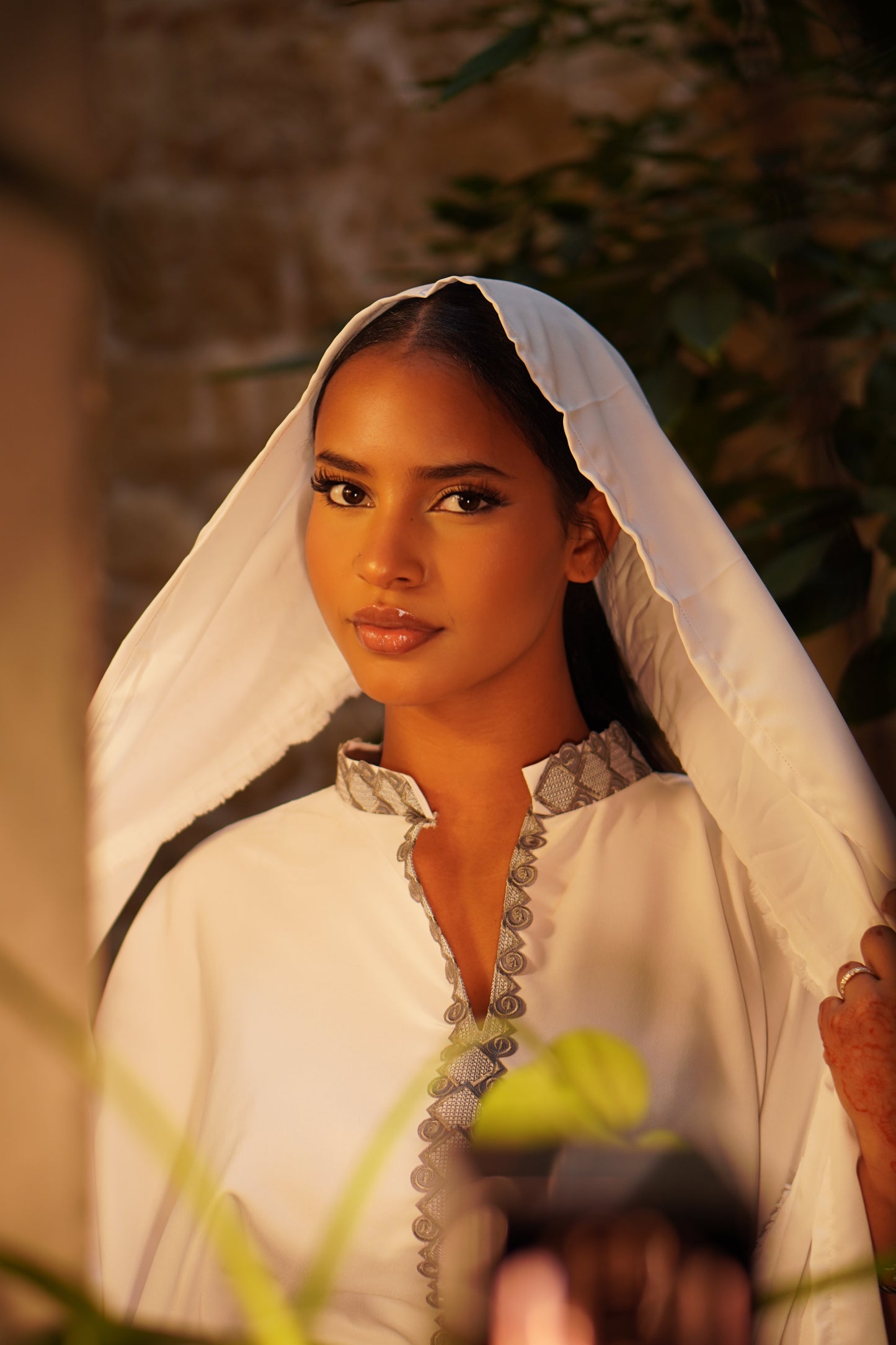 Femme portant la Hasna Dress blanche avec une broderie grise – il s’agit d’une robe longue blanche africaine en organza blanc, élégante