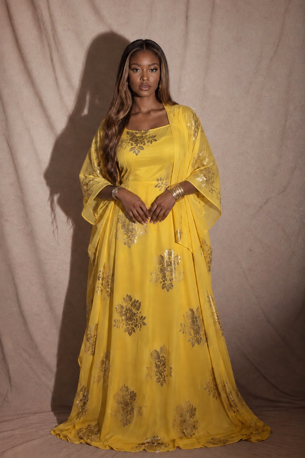 Femme portant un Dirac jaune à motifs dorés avec bijoux dorés – Maison Kemeti